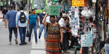 Personas caminando en la calle con mascarilla