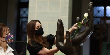 La locutora Corina Ardón cambia la Rosa de la Paz en el Patio de la Paz, del Palacio Nacional de la Cultura, con motivo de la conmemoración del Día del Locutor Profesional de Guatemala. .