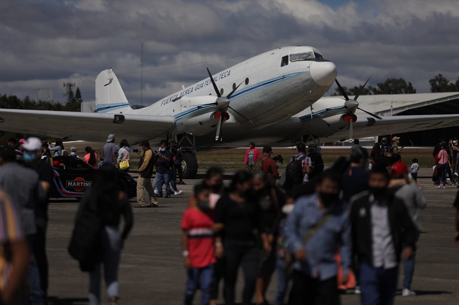 Asistentes a la conmemoración del centenario de la Fuerza Aérea Guatemalteca observan una de las aeronaves antiguas expuestas durante el evento. 
