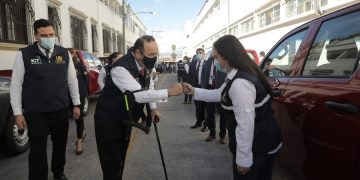 El presidente Alejandro Giammattei saluda a la viceministra de Administración de Trabajo, María Isabel Salazar, durante la entrega de 28 vehículos al Mintrab.