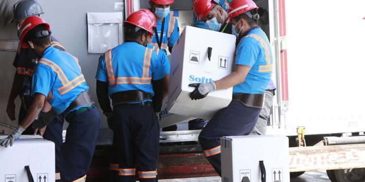 Personal descarga las cajas que contienen las dosis de la vacuna Pfizer que ingresaron este jueves a Guatemala.