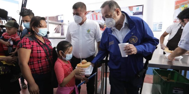 El presidente Alejandro Giammattei entrega alimentos a una mandre junto a su hijo, en el comedor social inaugurado en Camotán, Chiquimula. Foto Gilber García