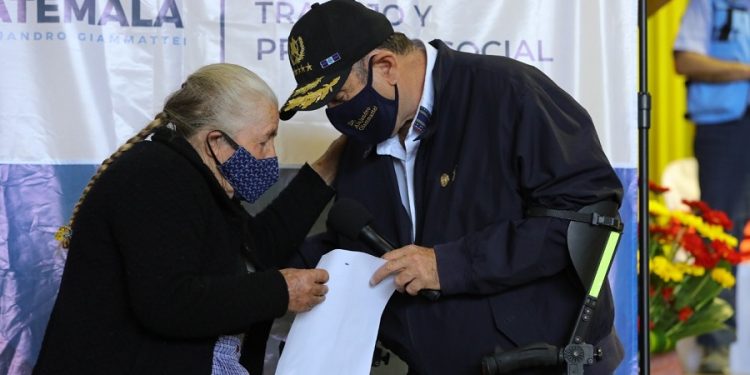 El presidente Alejandro Giammattei entrega, a anciana de San Marcos, la resolución que la acredita como beneficiaria del Programa del Adulto Mayor. /Foto: Álvaro Interiano