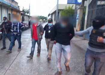 Agentes de la DEIC conducen a dos ersonas capturadas con dos paquetes de cocaína en Santa Cruz Verapaz.