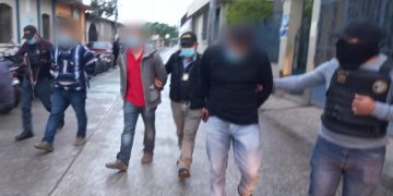 Agentes de la DEIC conducen a dos ersonas capturadas con dos paquetes de cocaína en Santa Cruz Verapaz.
