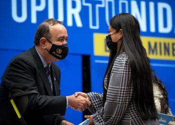 El presidente Alejandro Giammattei, saluda a una de las beneficiarias con la beca de atencion integral de enfermería.