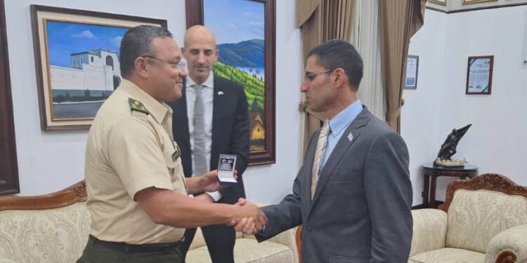 Ministro de la Defensa saludando al agregado militar israelí. De fondo, el embajador Curiel, de Israel. / Foto: Mindef.