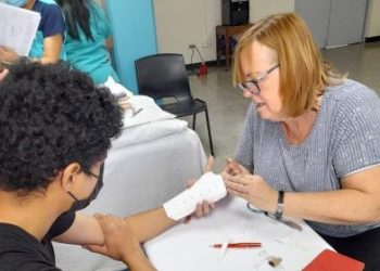 Una doctora estadounidense atiende a un afiliado del IGSS. Foto: IGSS.