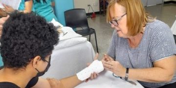 Una doctora estadounidense atiende a un afiliado del IGSS. Foto: IGSS.