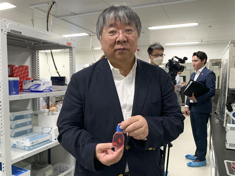 El profesor Yoshiki Sawa muestra un frasco con líquido en el que se encuentran las células.