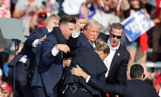 Agentes del Servicio Secreto de EE. UU. sacan al expresidente Donald Trump del lugar del atentado.