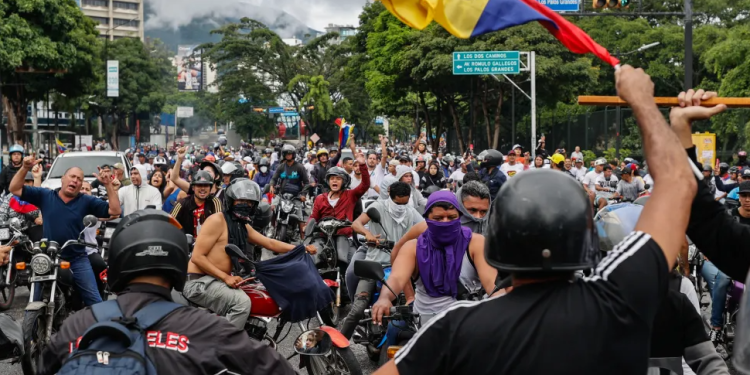 Manifestantes y fuerzas policiales enfrentadas en Venezuela. / Foto: EFE.