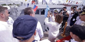 Karin Herrera lanza la botella de champán al Hunahpú. /Foto: Gobierno de Guatemala.