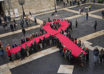 Un lazo memorial del sida se despliega en la plaza Sant Jaume. Barcelona, este domingo, en el que se celebra el Día Mundial del Sida. / Foto: EFE/Enric Fontcuberta.