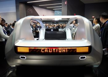 Asistentes la Feria Tecnológica de Consumo (CES) observan uno de los autos futuristas que se exhiben en esta gran convención en Las Vegas.