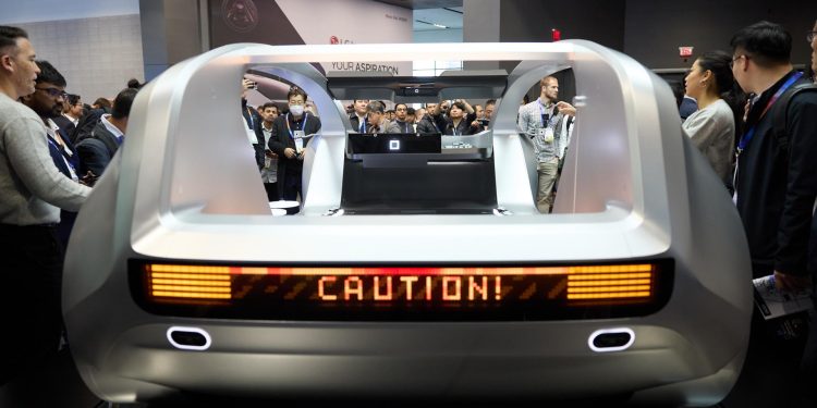 Asistentes la Feria Tecnológica de Consumo (CES) observan uno de los autos futuristas que se exhiben en esta gran convención en Las Vegas.