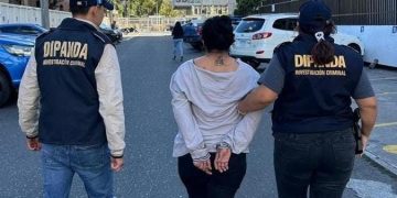 Agentes de la PNC trasladan a una mujer detinida en la zona 18, en acciones que forman parte de la lucha contra las extorsiones.