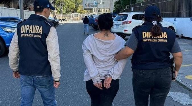 Agentes de la PNC trasladan a una mujer detinida en la zona 18, en acciones que forman parte de la lucha contra las extorsiones.
