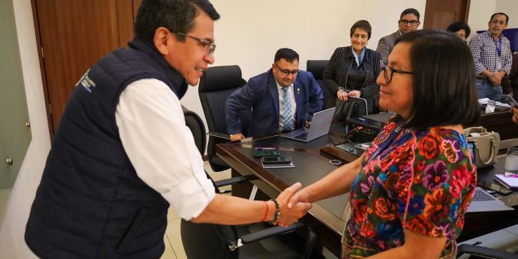 El titular del CIV, Miguel Ángel Bobadilla, saluda a la gobernadora de Chimaltenango, María del Tráncito Calán, en reunión sobre reparación de carreteras en ese departamento.