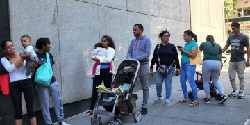 Migrantes en Nueva York esperan ayuda en las afueras de una ONG católica.