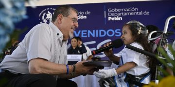 La pequeña Allison Nicole Najarro entrega una llave al presidente Bernardo Arévalo en la escuela La Paz, en San Benito, Petén.