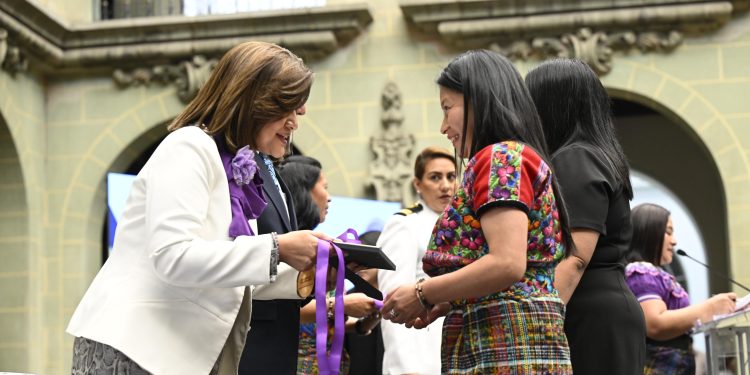 La vicepresidenta Karin Herrera entrega el diploma y la medalla a la excelencia laboral una de las 24 mujeres galardonadas con motivo del Día Internacional de la Mujer.