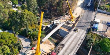 Grúas de gran tamaño trabajan en la colocación de vigas longitudinales del segundo puente que se construye en el km 17.5 de la ruta al Pacífico. /Foto: Covial