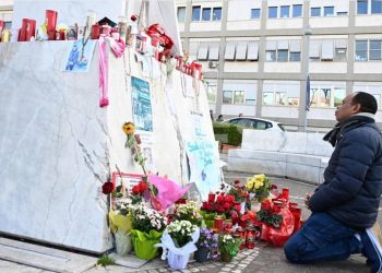 Un feligrés ora junto a un altar improvisado a los pies de un monumento al papa Juan Pablo II afuera del Hospital Policlínico Gemelli, donde Francisco cumple 19 días internado.