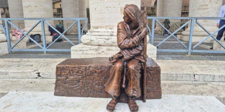 Vista de frente la nueva escultura en la Plaza de San Pedro representa a una persona sin hogar.
