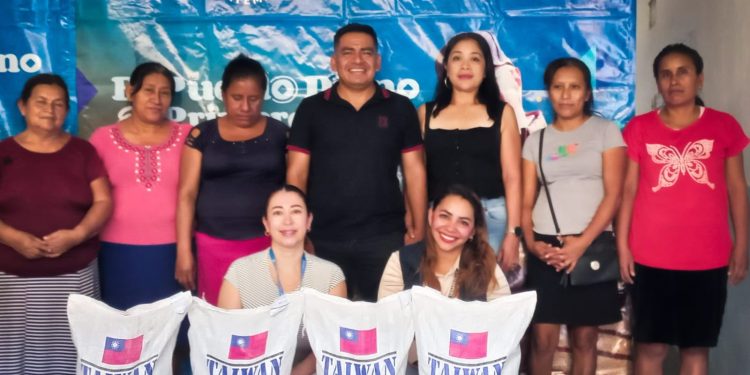 Personal del Fodes posan con beneficiados con entrega de arroz en Suchitepéquez.