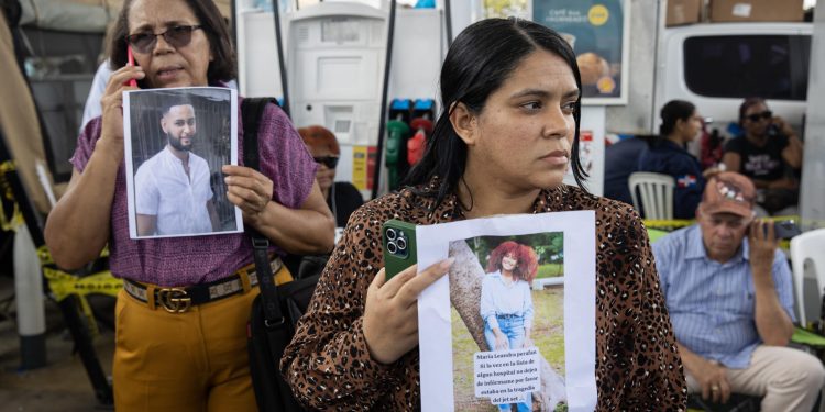 Familiares de desaparecidos esperan cerca de la discoteca por información sobre sus parientes.