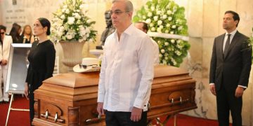 El presidente dominicano, Luis Abinader, hace guardia de honor ante el férretro del cantante Rubby Pérez, quien murió en la tragedia de la discoteca.