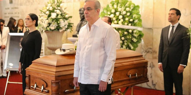 El presidente dominicano, Luis Abinader, hace guardia de honor ante el férretro del cantante Rubby Pérez, quien murió en la tragedia de la discoteca.