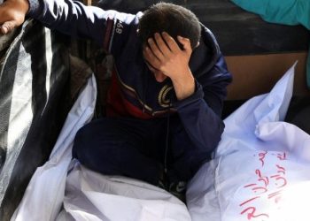 Un hombre llora junto a los cuerpos de familiares en Gaza.