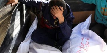Un hombre llora junto a los cuerpos de familiares en Gaza.