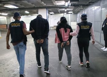 Agentes de la Inspectoría General de la PNC conducen a dos de los policías capturados.