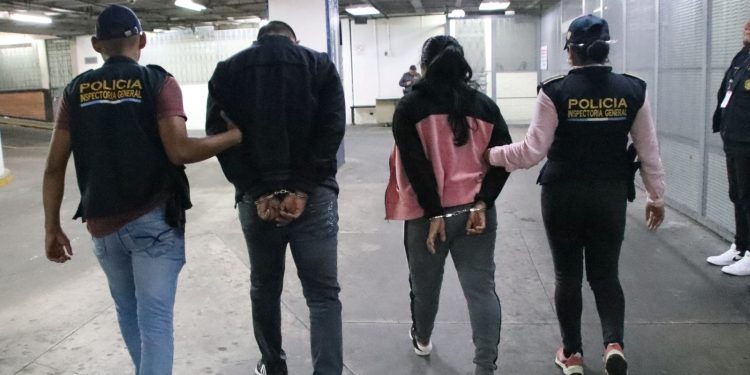 Agentes de la Inspectoría General de la PNC conducen a dos de los policías capturados.