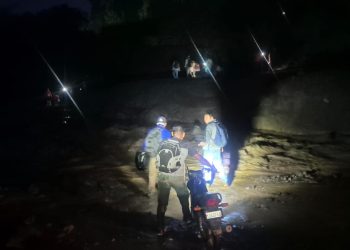 Personas atravesando el río El Jute, cuya corriente arrastra material arrojado por el volcán de Fuego, ramas, rocas y demás. / Foto: Conred.