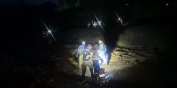 Personas atravesando el río El Jute, cuya corriente arrastra material arrojado por el volcán de Fuego, ramas, rocas y demás. / Foto: Conred.