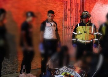 Socorristas cubren el cuerpo de una de las personas fallecidas en ataque en velatorio de pandillero.