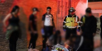 Socorristas cubren el cuerpo de una de las personas fallecidas en ataque en velatorio de pandillero.