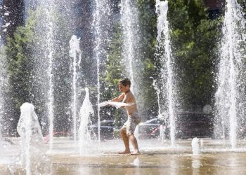 Un niño se refresca en una fuente en Washington, debido al extenuante calor que azota EE. UU.