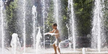 Un niño se refresca en una fuente en Washington, debido al extenuante calor que azota EE. UU.