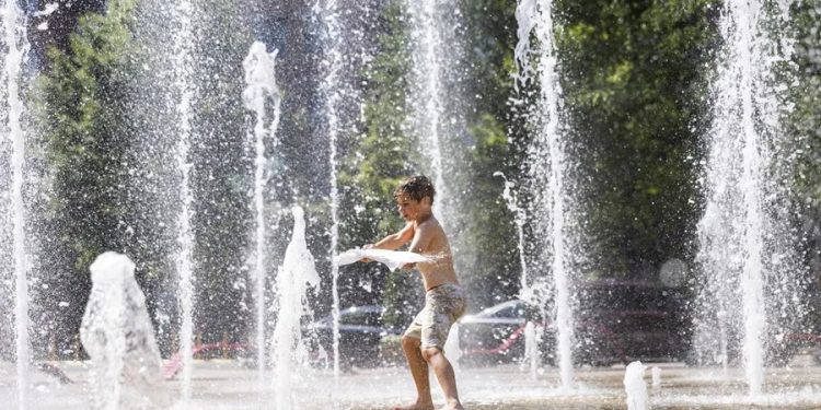 Un niño se refresca en una fuente en Washington, debido al extenuante calor que azota EE. UU.
