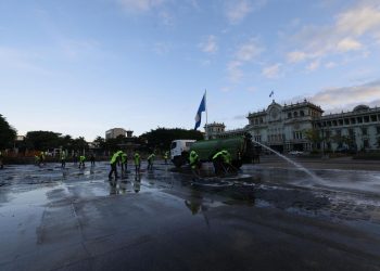 Empleados municipales lavan la Plaza de la Constitución luego de que un grupo de maestros del STEG abandonara el lugar.