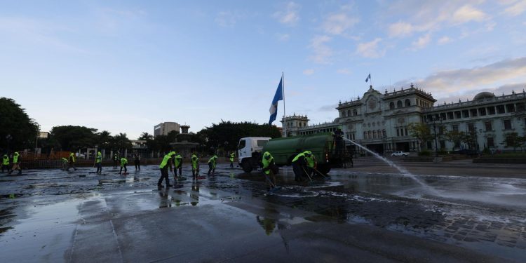 Empleados municipales lavan la Plaza de la Constitución luego de que un grupo de maestros del STEG abandonara el lugar.