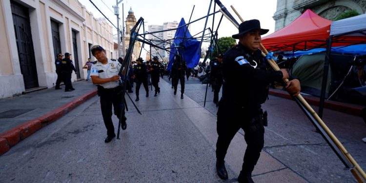 Agentes de la PNC retiran champas que obstaculizaban el paso en los alrededores del Palacio Nacional de la Cultura.