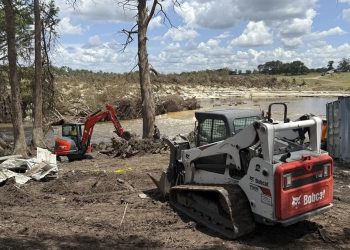 Maquinaria trabaja en el retiro de escombros por las inundaciones en Texas.
