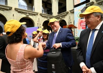 Jóvenes integrantes de la Red Juventud Chispuda entregan al presidente Bernardo Arévalo una gorra y una mochila.
