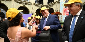 Jóvenes integrantes de la Red Juventud Chispuda entregan al presidente Bernardo Arévalo una gorra y una mochila.
